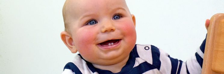 Startpunkt Elterncafé Baby lacht in die Kamera