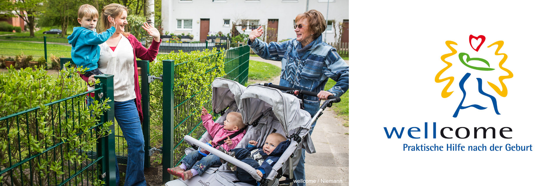 Eine Mutter mit einem Kind auf dem Arm winkt einer Seniorin, die einen Zwillings-Kinderwagen schiebt